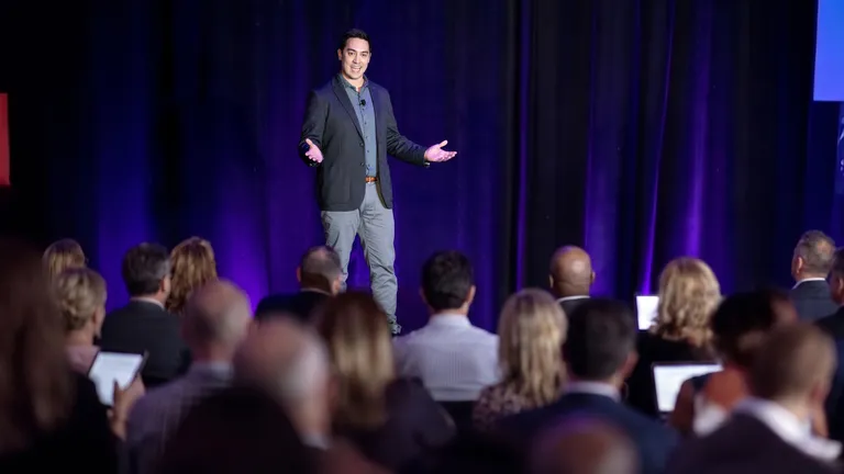 Paul Takisaki presenting on stage, AI consultant serving Coeur d'Alene and North Idaho, former Verizon AVP.